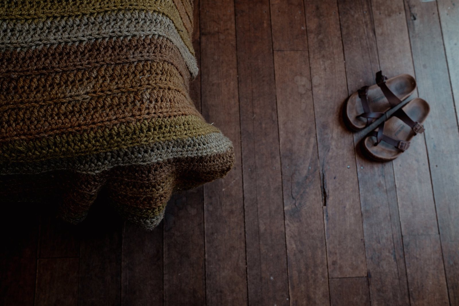 Crocheted chair and sandals on warm timber floorboards
